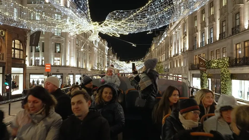 Passengers beneath a brilliant canopy of Regent Street Christmas angels